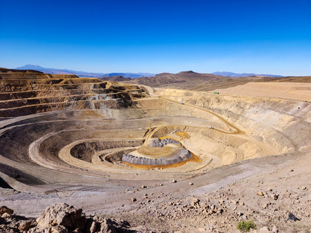Aerial view of an open-pit mine with closed and remediated benches and mineral extraction platforms