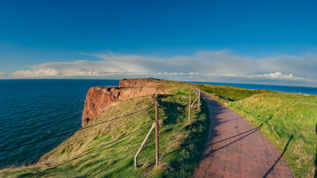 pedestrian walkway made of stone cobblestones built in gardens next to a sea cliffの写真素材