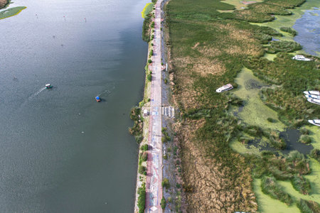 Aerial view of a boardwalk built in the middle of a lake with embankments and riprap
