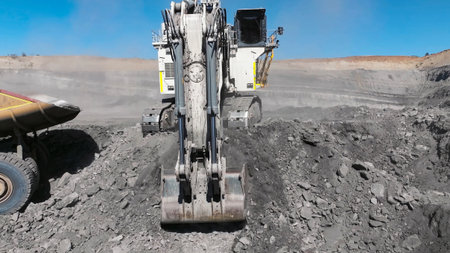 Process of extracting and loading minerals with giant excavators into mining dump trucks