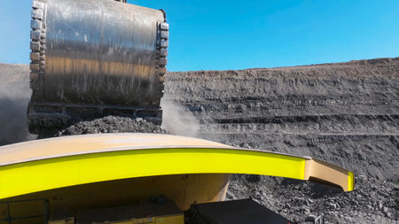 Process of extracting and loading minerals with giant excavators into mining dump trucks