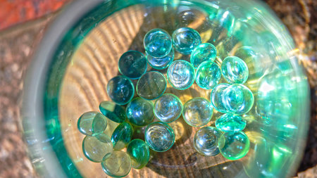 View emerald-colored gems inside a glass containerの写真素材