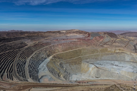 Panoramic view of a huge open-pit mine with hundreds of benches and mining roads.