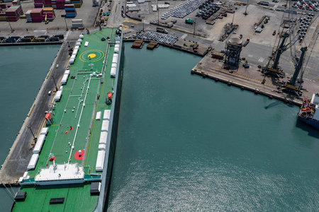Seaport with a huge ro-ro ship in the process of unloading cars brought from Asian countries