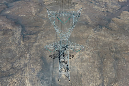 Aerial view of a huge 440 kv high-voltage tower in coastal deserts