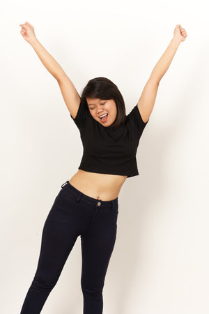young happy and beautiful Asian Korean woman in black T-shirt and jeans celebrating success with...