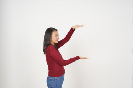 Young Asian woman in Red t-shirt Measuring and Holding Big Product isolated on white backgroundの写真素材