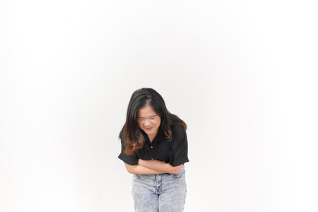 Young Asian woman suffering stomachache wearing Black t-shirt and jeans isolated on white backgroundの写真素材