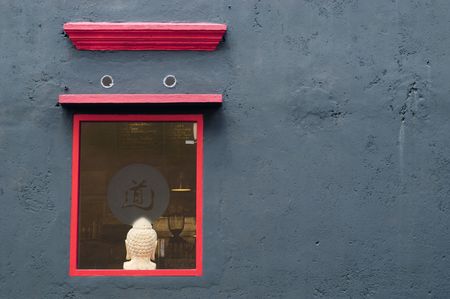 A red painted window border on a black wall.の写真素材