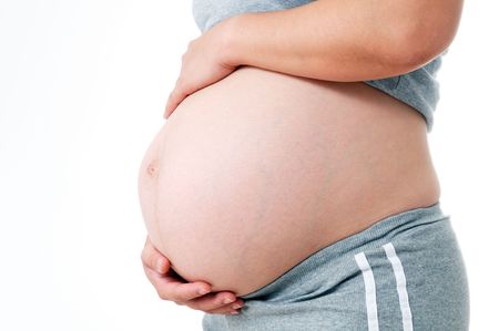 Pregnant woman holding her belly over white background.