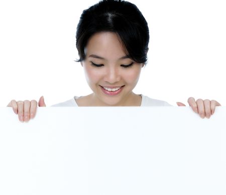 Closeup of an attractive woman holding billboard over white background.の写真素材