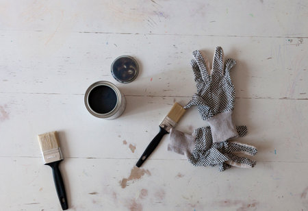 Top view of table renovation with brushes, paint and gloves. Flat Lay
