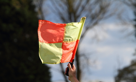 Hand holding a flag at a sporting eventの写真素材