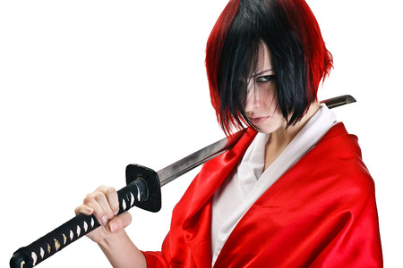Isolated image. Brunette with short dark and red hair with a stern look holding by two hands a sword katanaの写真素材