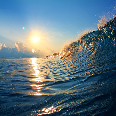 rough colored ocean wave falling down at sunset timeの写真素材