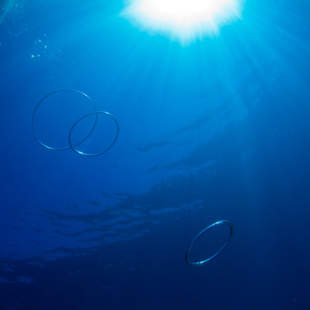 abstract underwater design template sunshine in water surface with air rings and bubblesの写真素材