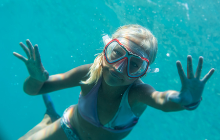 A small blonde girl underwater in the seaの写真素材