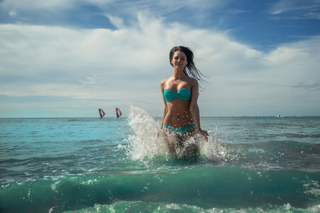 Happy girl in tropical sea water with splashesの写真素材