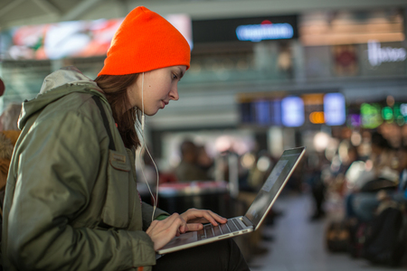 A girl working with laptop in waiting hall in an airportの写真素材