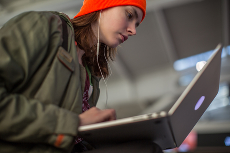 A girl working with laptop in waiting hall in an airportの写真素材