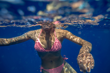 Sexy young girl in pink bikini underwaterの写真素材