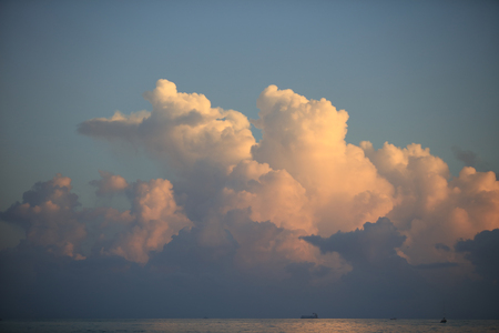 Beautiful clouds over ocean sunset water surface with reflectionsの写真素材