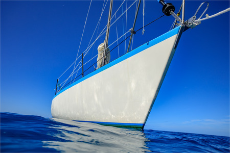 Sailboat in calm blue water with reflectionsの写真素材