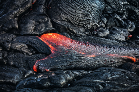 Red Orange vibrant Molten Lava flowing near hawaiian volcano with glossy crispy backgroundの写真素材