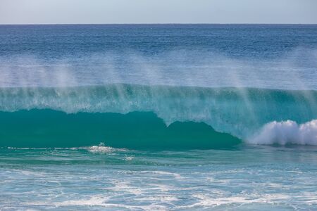 Big blue surfing wave crashing