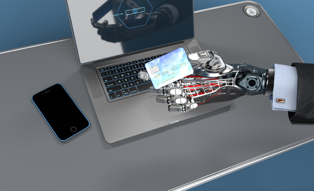 Closeup image of detailed cybernetic arm holding plastic card with electronic chip and laptop on background. Artificial intelligence manipulating objects. 3d illustrationの写真素材