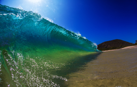 Big bright beautiful ocean wave breaking barrel on tropical beachの写真素材