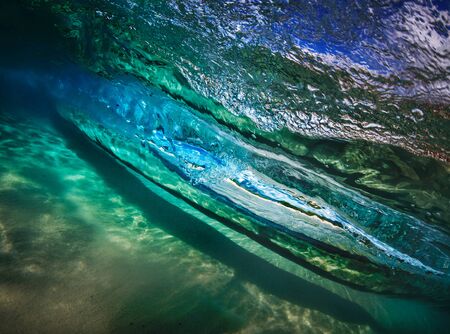 Underwater view of rolling surfing wave with caustic light. Copy space with nobodyの写真素材