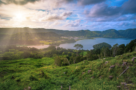 Beautiful sunset volcanic lake among mountains with green lush and trees in Ciete Cidades valley in...