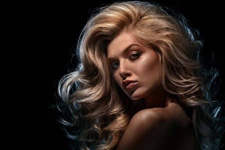 Beauty headshot of fashion blonde model on dark backgroundの写真素材