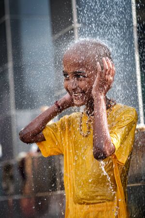 Close-up of young boy devotee having shower ritual in Thaipusam Festival.のeditorial素材