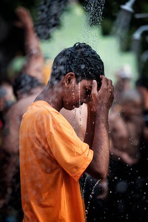 Close-up of young boy devotee having shower ritual in Thaipusam Festival.のeditorial素材