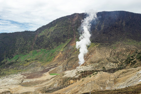 Active Volcanic Region with Rising Steam and Rugged Hills