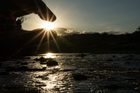 grabbing sun at sunsetの写真素材