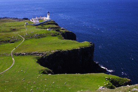 blue sea and cliffs with a far lighthouseの写真素材