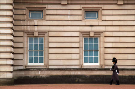 An elaborately dressed member of the Queenâs Guard performs his duties in front of Buckingham Palace in London, Englandのeditorial素材