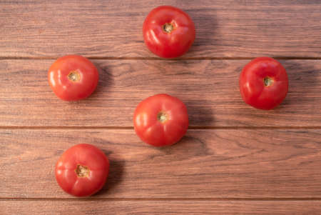 many large fresh red tomatoes on a wooden table close upの写真素材