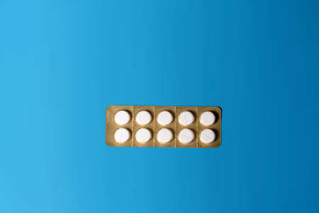 a sealed white pill blister on a blue colored background top view