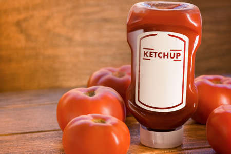 ketchup sauce with many tomatoes around on brown wooden boardの写真素材
