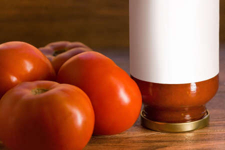 many fresh red tomatoes with a glass of tomato paste wood backgroundの写真素材