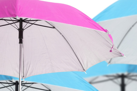 Close up pink umbrella on blue umbrella background の写真素材