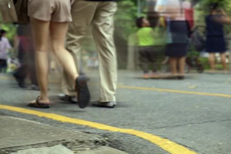 Motion blur of people walking on the street, zoom on leg and soft focus.