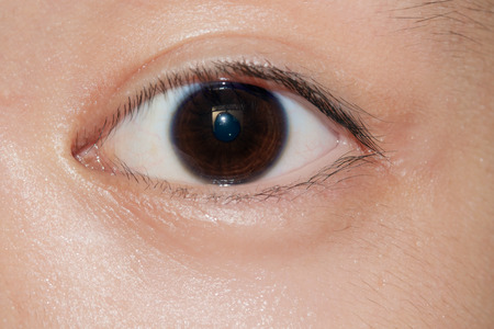 Close up of staring eye. Asian young boy.の写真素材