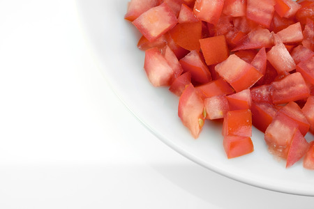 Pile of chopped fresh tomato on white plate.の写真素材