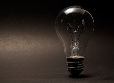 Light bulb on black background. Dark tone.の写真素材