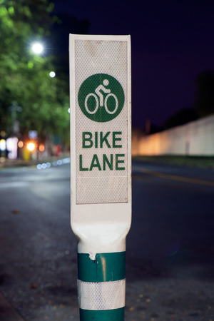 Bike lane sign on road at night.の写真素材